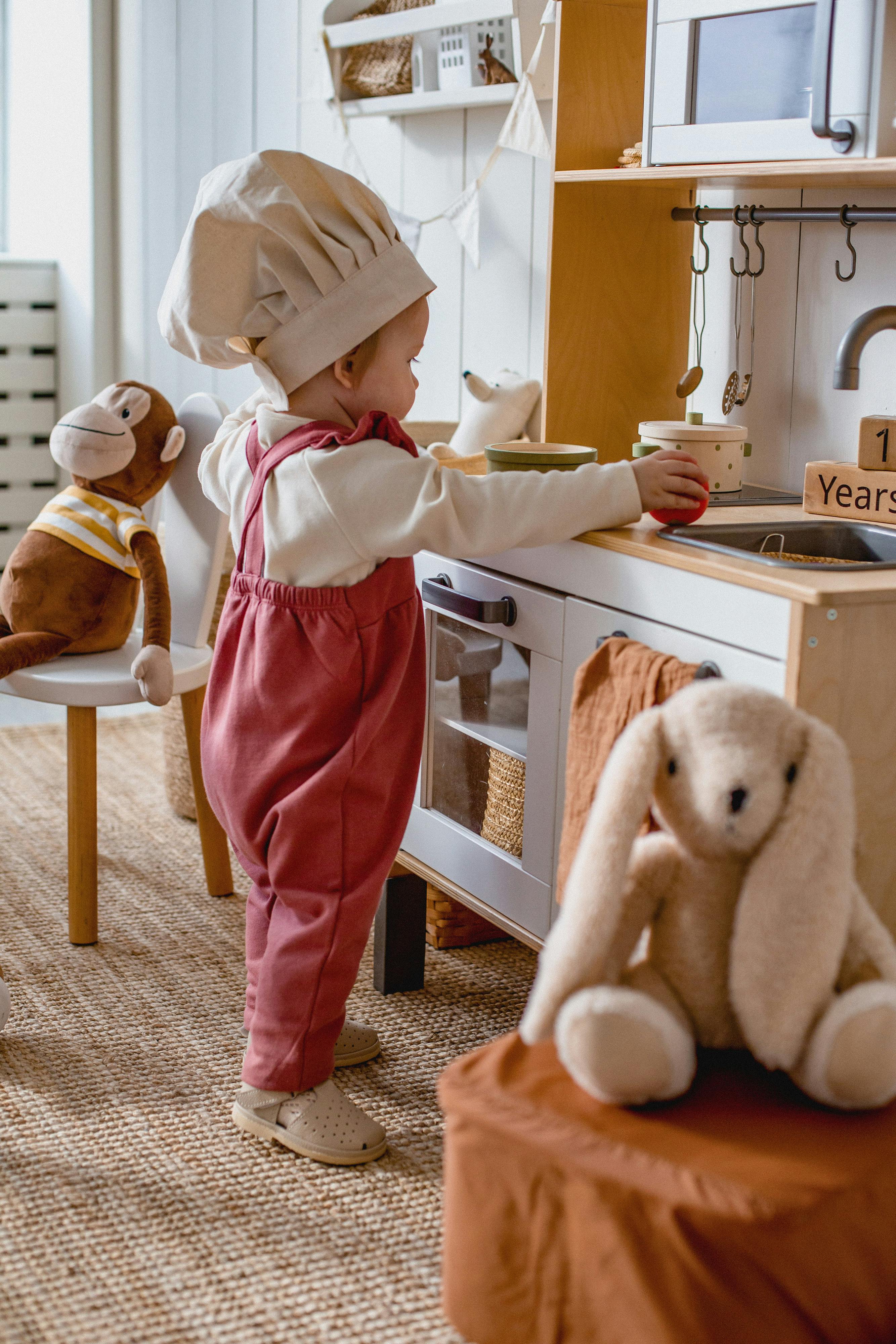 a baby is playing with her cooking set 